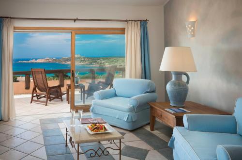 a living room with a couch and chairs and a table at Hotel Marinedda Thalasso & Spa in Isola Rossa