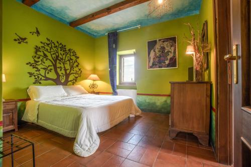 a bedroom with a bed in a room with green walls at L'orto di Hans in Soriano nel Cimino