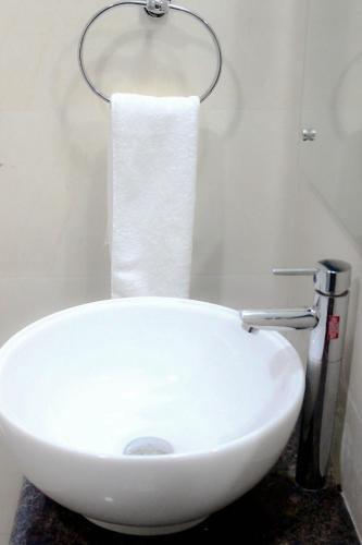 a white sink in a bathroom with a roll of toilet paper at Jade Vine Resort in Shogi