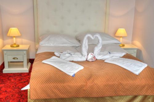 a bedroom with a bed with towels and two lamps at GWAREK Centrum Wypoczynkowe in Ustroń