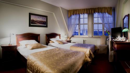 a hotel room with two beds and a window at Hotel im. Jana Pawła II in Wrocław