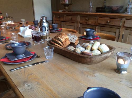 a table with a bowl of bread and cookies on it at Nokernote in Tienen