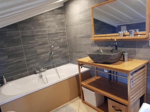 a bathroom with a sink and a bath tub and a mirror at T2 avec accès piscine SUD- OUEST de la Réunion in Les Cocos