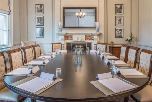 a large table in a room with a fireplace at De Vere Wokefield Estate in Reading
