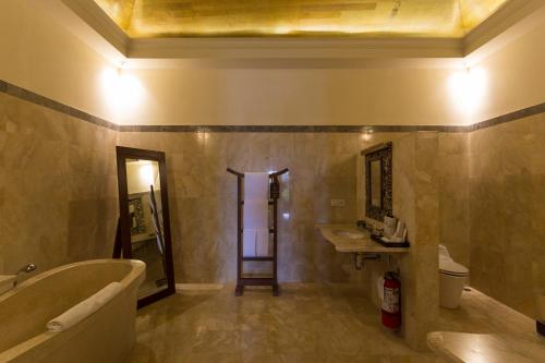 a bathroom with a bath tub and a sink at Plataran Borobudur in Borobudur