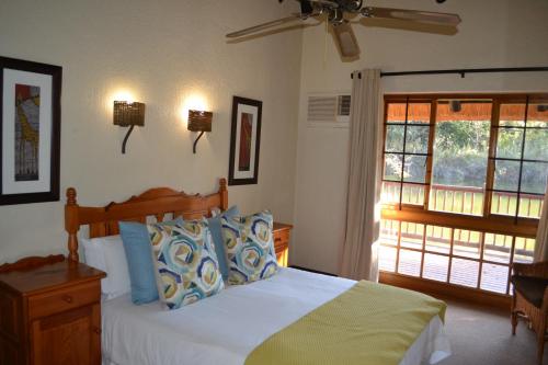 a bedroom with a bed and a window at Kruger Park Lodge - Golf Safari SA in Hazyview