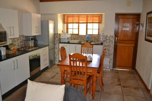 a kitchen with a wooden table and chairs in it at Kruger Park Lodge - Golf Safari SA in Hazyview