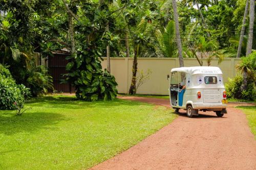 a small white caravan parked on a dirt road at Good Karma Villa in Bentota