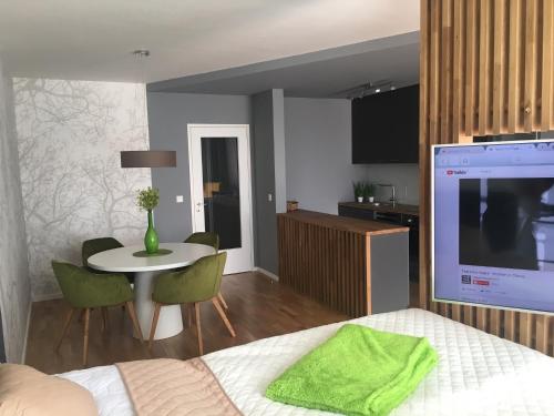 a bedroom with a bed and a table and a kitchen at Apartment DOWNTOWN in Brno