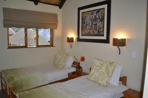 a hotel room with two beds and a window at Kruger Park Lodge - Golf Safari SA in Hazyview