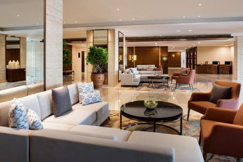 a living room with white couches and a table at Fraser Suites Muscat in Muscat