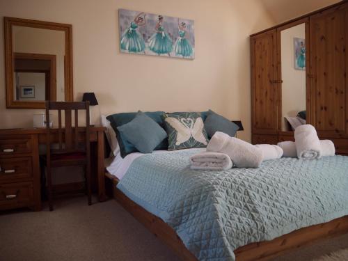 a bedroom with a bed with towels on it at Blossom Cottage in Lonmore