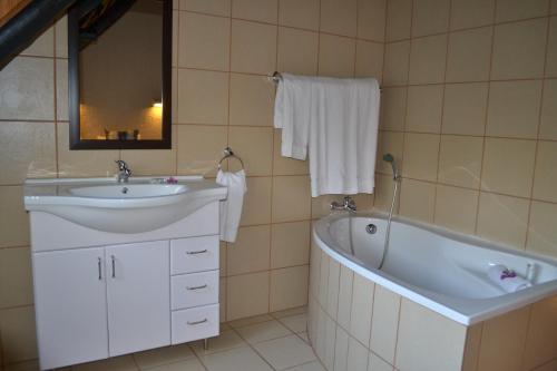 a bathroom with a sink and a bath tub at Kruger Park Lodge - Golf Safari SA in Hazyview