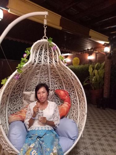 a woman is sitting in a hammock at Ruenthip Homestay in Bangkok