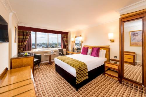 a hotel room with a bed and a large window at Copthorne Tara Hotel London Kensington in London