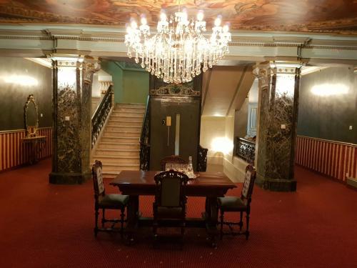 a dining room with a table and a chandelier at NF Palace Old City Bucharest in Bucharest