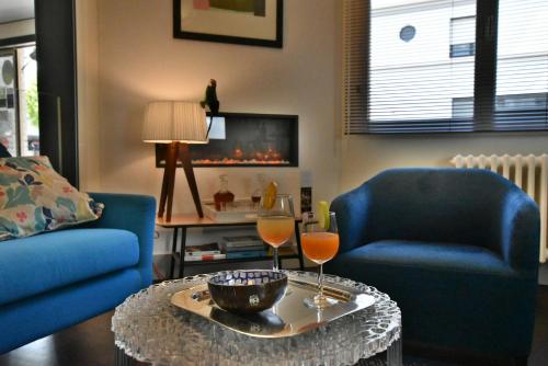 a living room with two chairs and a table with wine glasses at Hôtel Escale Oceania Lorient in Lorient