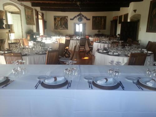 uma grande sala com mesas e cadeiras com copos de vinho em Pazo Vilabade em Vilabade