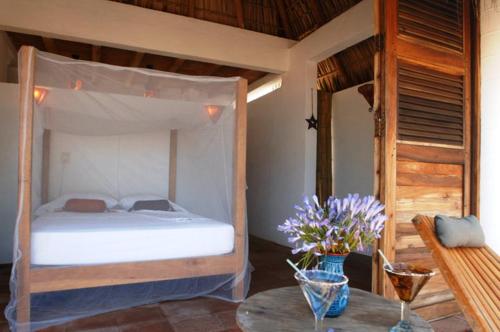 a bedroom with a bed and a table at Un Sueño Cabañas del Pacífico in San Agustinillo
