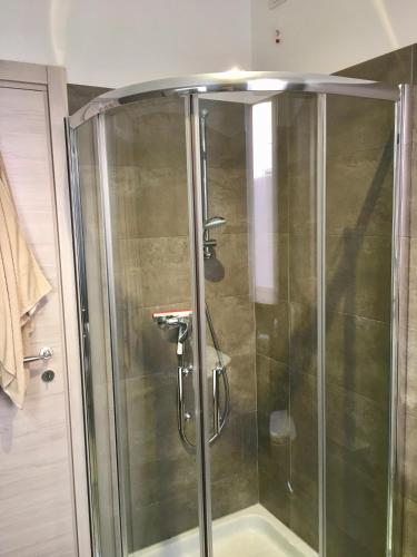 una ducha con puerta de cristal en un baño en Riflessi di Lago, en Dorio