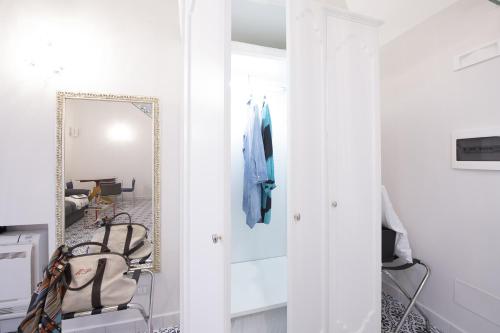 a hallway with a mirror and a chair in a room at DieciSedici in Amalfi