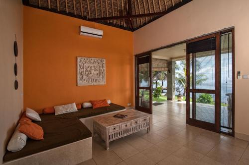 uma sala de estar com um sofá e uma mesa em Relax Bali Dive & SPA ocean front resort em Tulamben