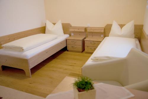 um pequeno quarto com 2 camas e um sofá em Landhaus Essl em Dietach