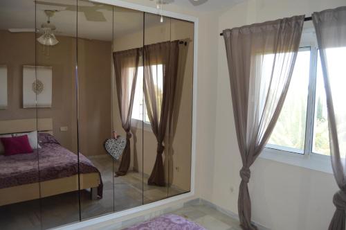 um quarto com uma cabina de duche em vidro, uma cama e uma janela. em Puebla Agata em Marbella