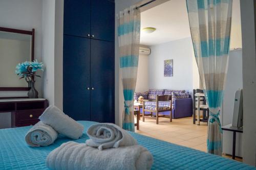 una camera da letto con un letto blu con sopra degli asciugamani di Manto On The Beach Apartments a Barbati