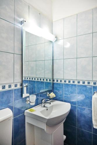 a bathroom with a white sink and blue tiles at Hotel Olimpic in Jupiter