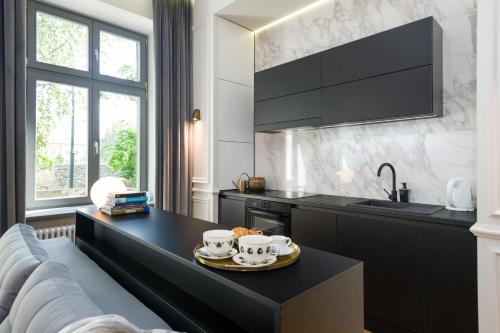 a kitchen with a black table with two mugs on it at apartament PAULOVE in Krakow