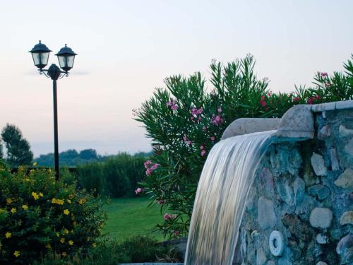 a waterfall on a stone wall next to a street light at B&B Borgo Tre Case in Cavriana
