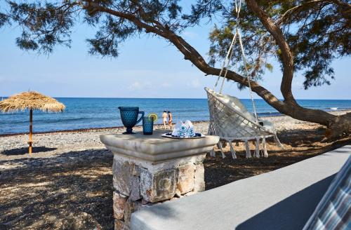 a swing and a chair on the beach at Almyriki Beach Villa in Monolithos