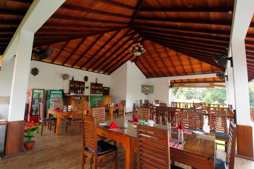a dining room with wooden tables and chairs at Rockery Villa Ayurveda in Bentota
