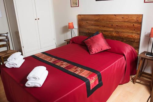 a bedroom with a red bed with towels on it at Fashion House in Barcelona
