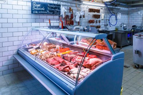 a display case with meat and other meats in a store at Hotel Spitzenpfeil in Michelau