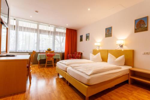 ein Hotelzimmer mit einem Bett und einem Tisch in der Unterkunft Hotel Spitzenpfeil in Michelau