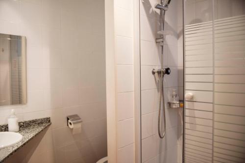 a white bathroom with a shower and a sink at Fashion House in Barcelona