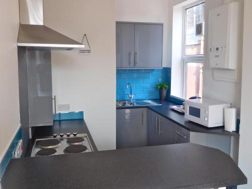 a kitchen with a sink and a stove top oven at The Wrens in Leeds