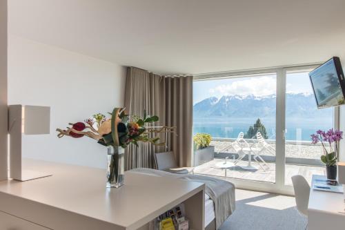 a living room with a view of the mountains at Hotel Lavaux in Cully