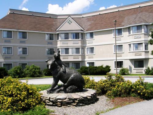 a statue of a bear in front of a building at Black Bear Inn, an Ascend Collection Hotel in Orono