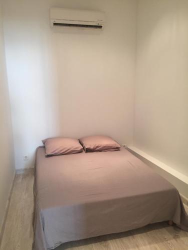 アジャクシオにあるT2 centre ville Ajaccioのピンクの枕が付くベッドが備わる小さなベッドルーム1室
