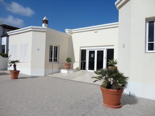 una casa blanca con macetas delante de ella en Casa Cariño, en Playa Honda