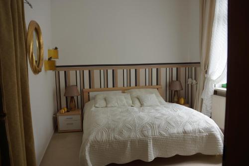 a bedroom with a bed and two lamps and a mirror at Ferienwohnung Regina in Mühlhausen