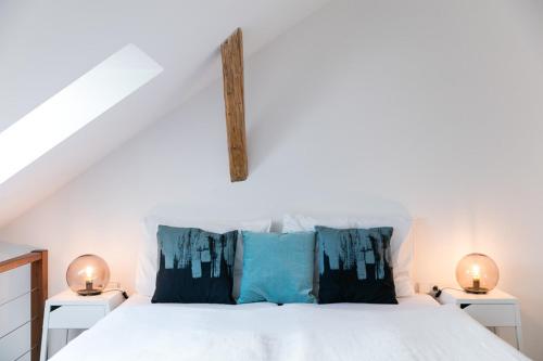 a bedroom with a white bed with blue pillows at Pytloun Apartments Liberec in Liberec
