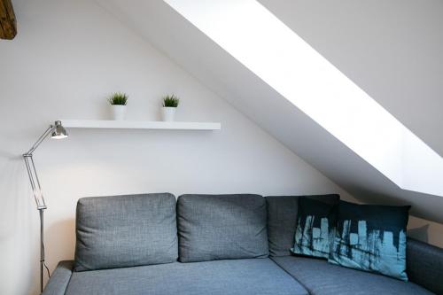 a living room with a couch in a attic at Pytloun Apartments Liberec in Liberec