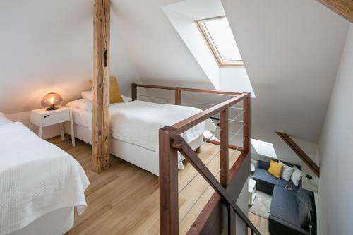 een kleine zolderslaapkamer met 2 bedden en een trap bij Pytloun Apartments Liberec in Liberec