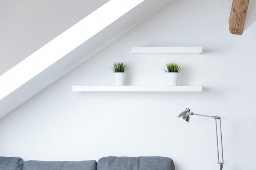 a living room with white walls and white shelves with potted plants at Pytloun Apartments Liberec in Liberec