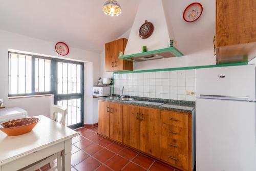 フリヒリアナにあるLa Casa del Molinoのキッチン(木製キャビネット、白い冷蔵庫付)
