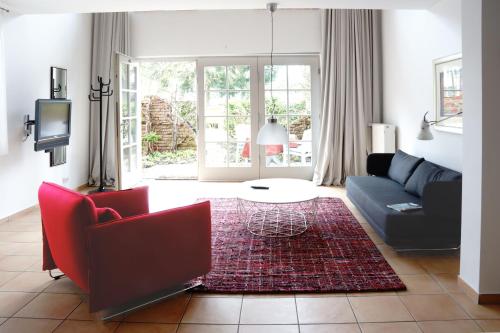 a living room with a blue couch and red chairs at Ferien in Himmelpfort in Himmelpfort
